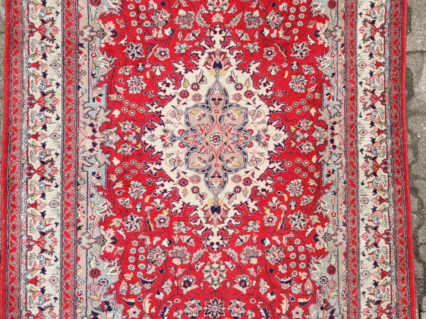 Vintage wool rug in crimson red with ivory and navy blue patterns.
