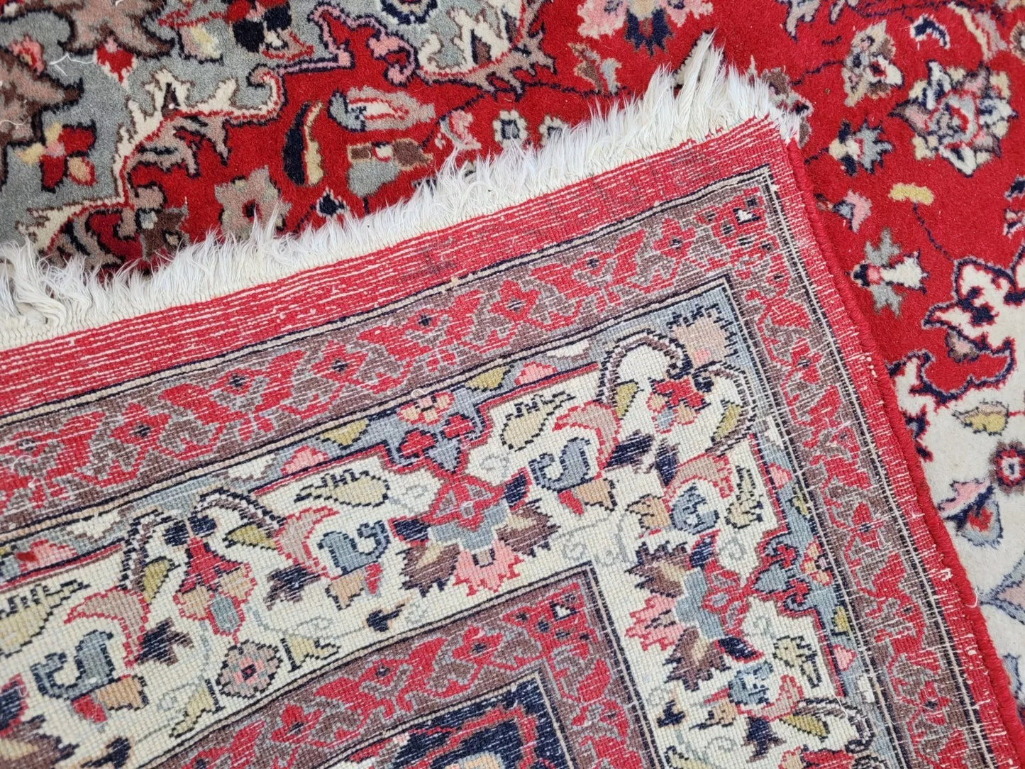 Detailed view of the rug's soft gray and pale pink accents.