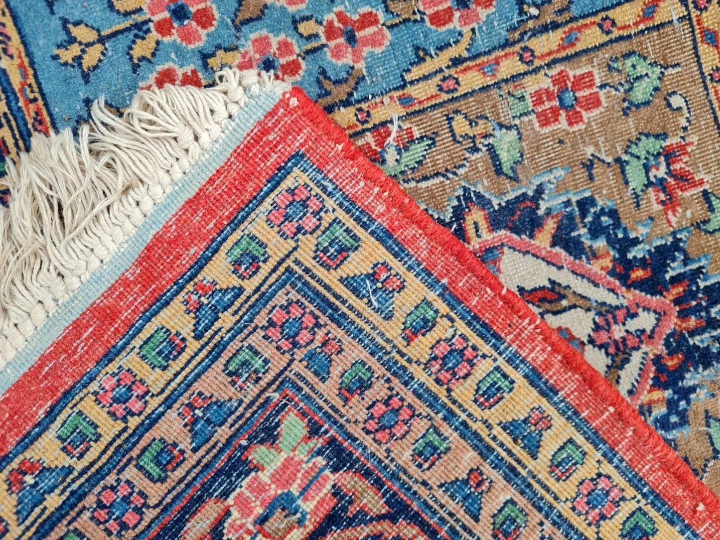 Close-up of patterned rugs with intricate designs and fringes.