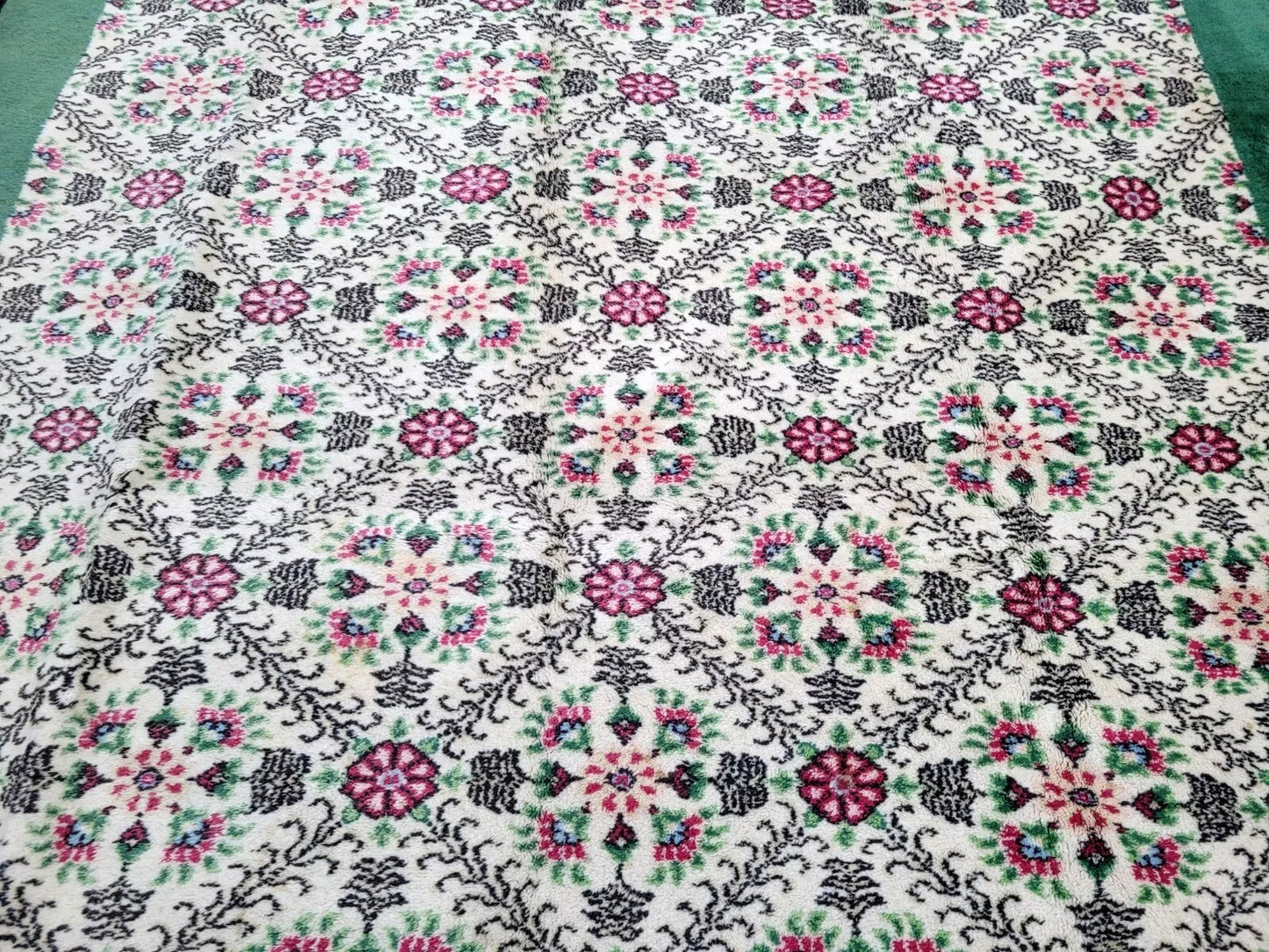Turkish rug showing deep magenta medallions on floral motifs.