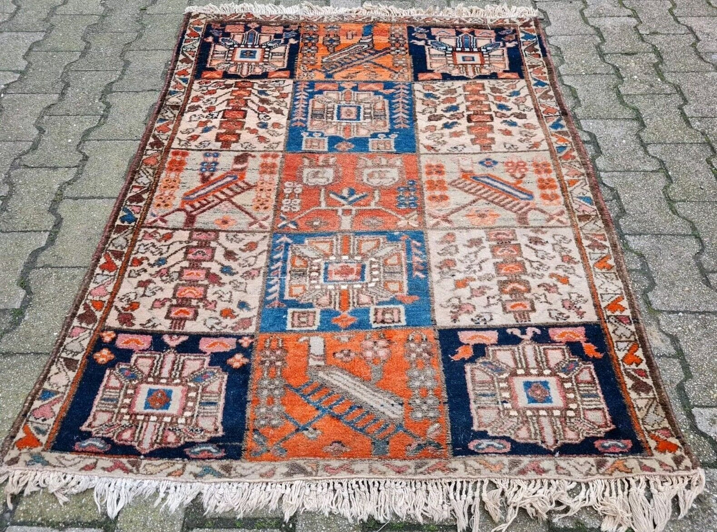 Persian tribal rug in deep reds, soft blues, and ivory.