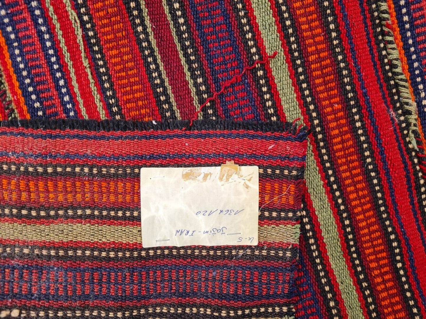 Persian flat-weave rug showing fiery oranges and earthy reds.