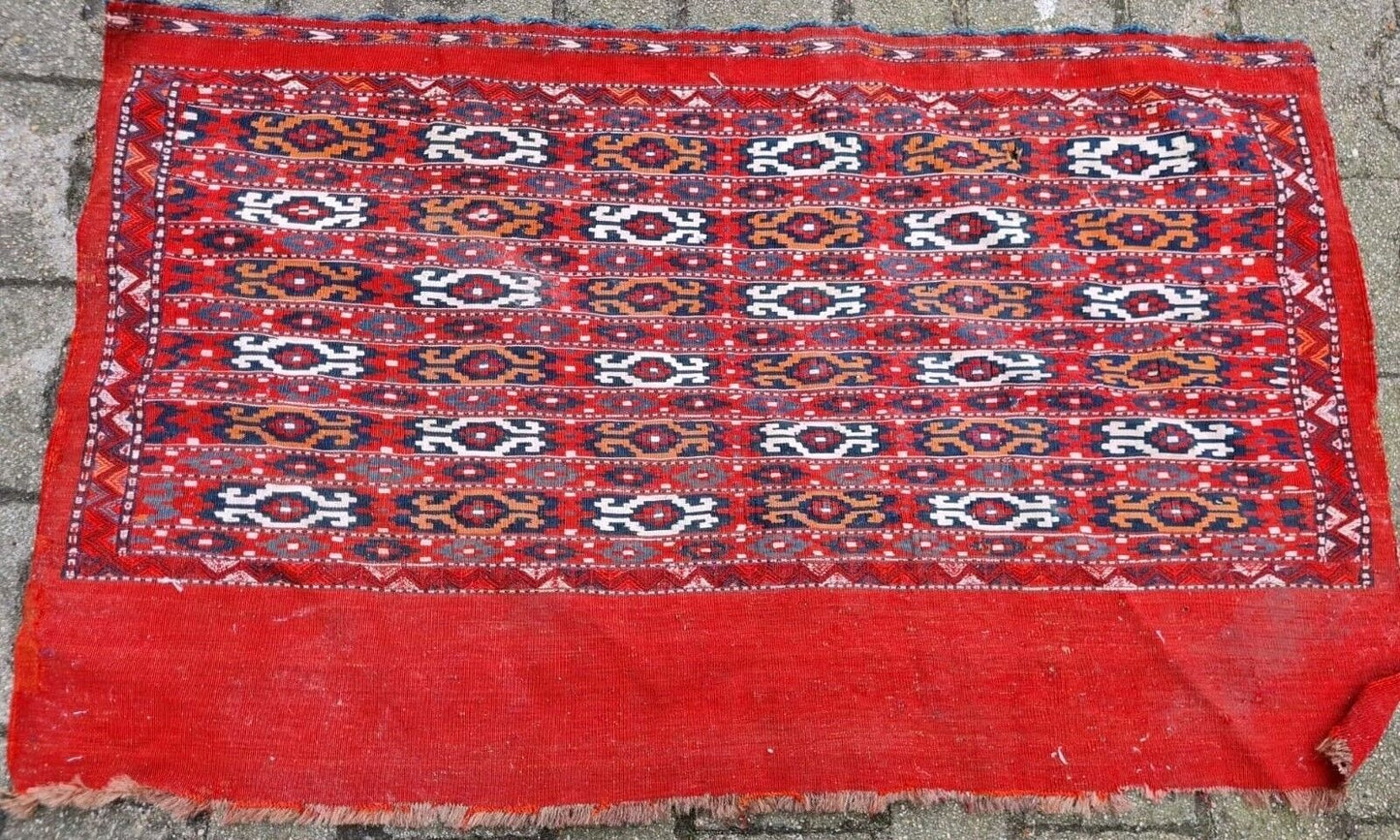 Handwoven rug with white, black, and warm orange accents.