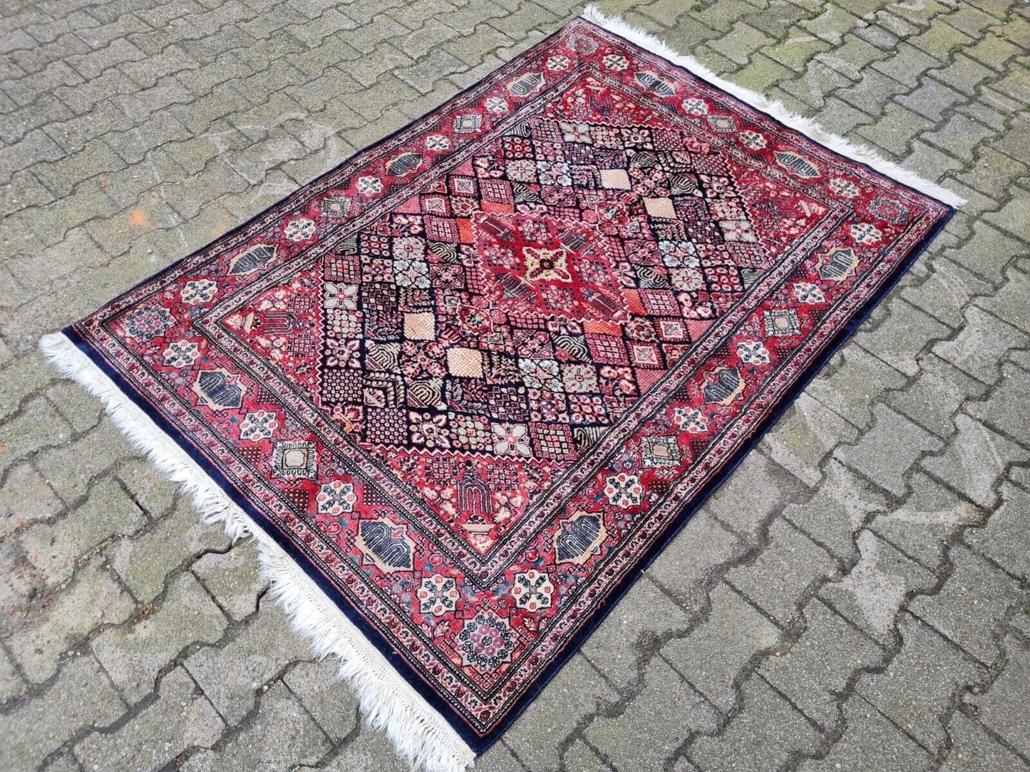 Wool rug featuring a deep navy blue field and intricate florals.