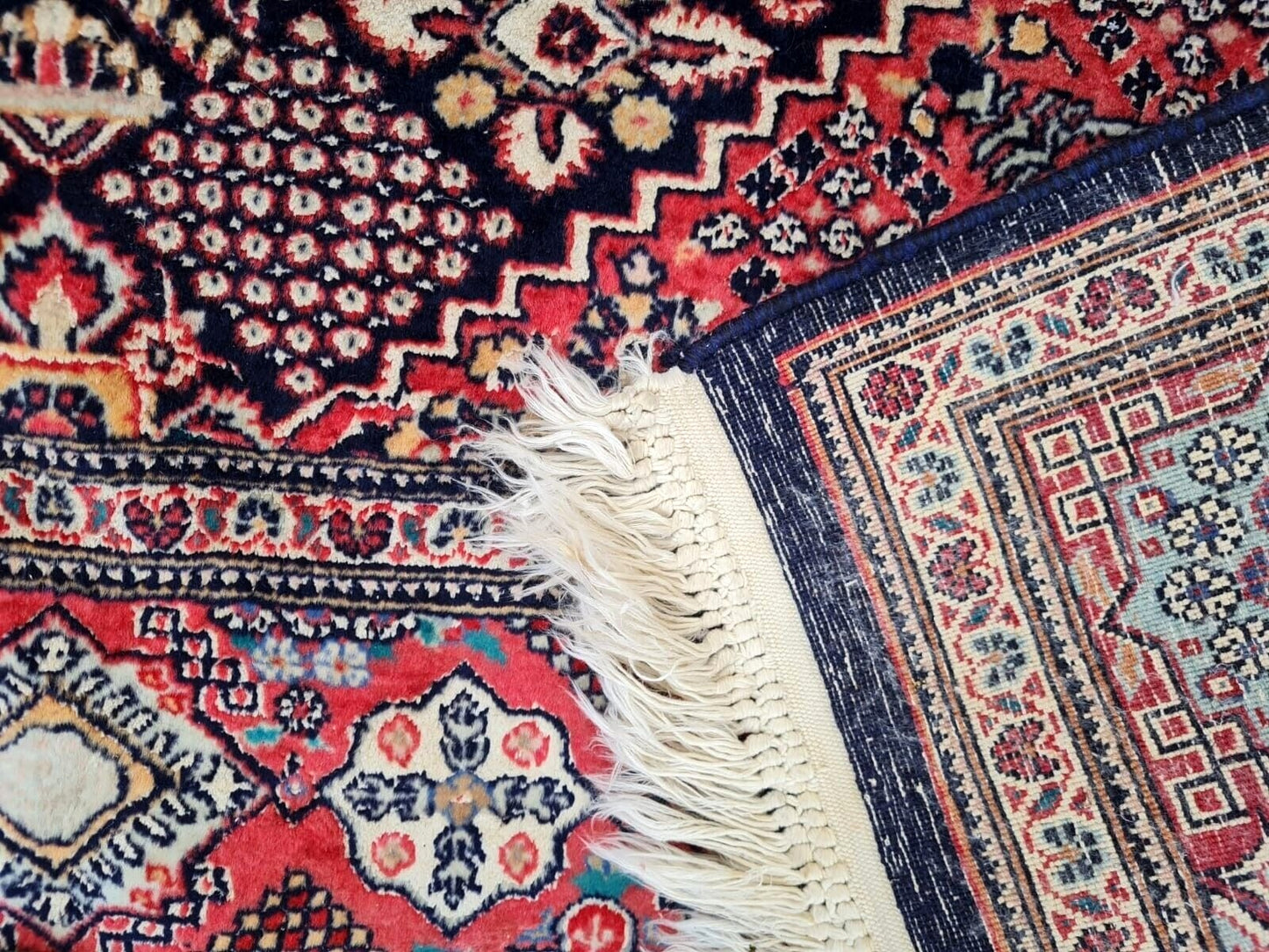 Antique Kashan rug with vibrant cream, pink, and light blue accents.