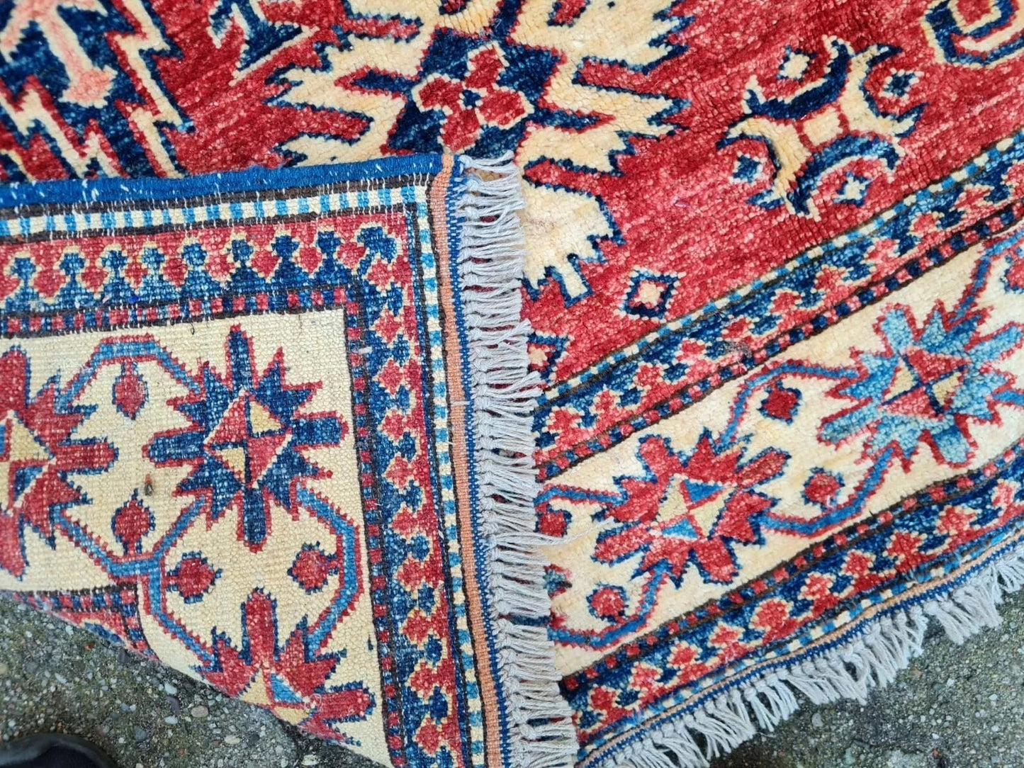 Geometric tribal motifs in red and blue Kazak rug