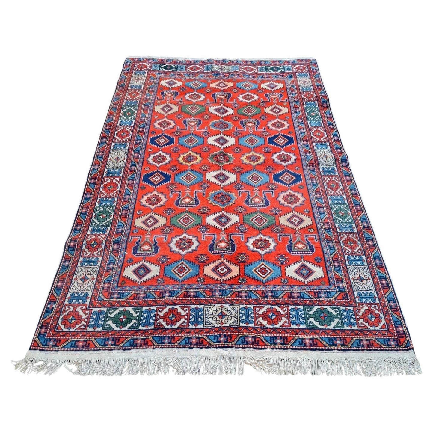handmade vintage Kazak rug with red field and geometric patterns