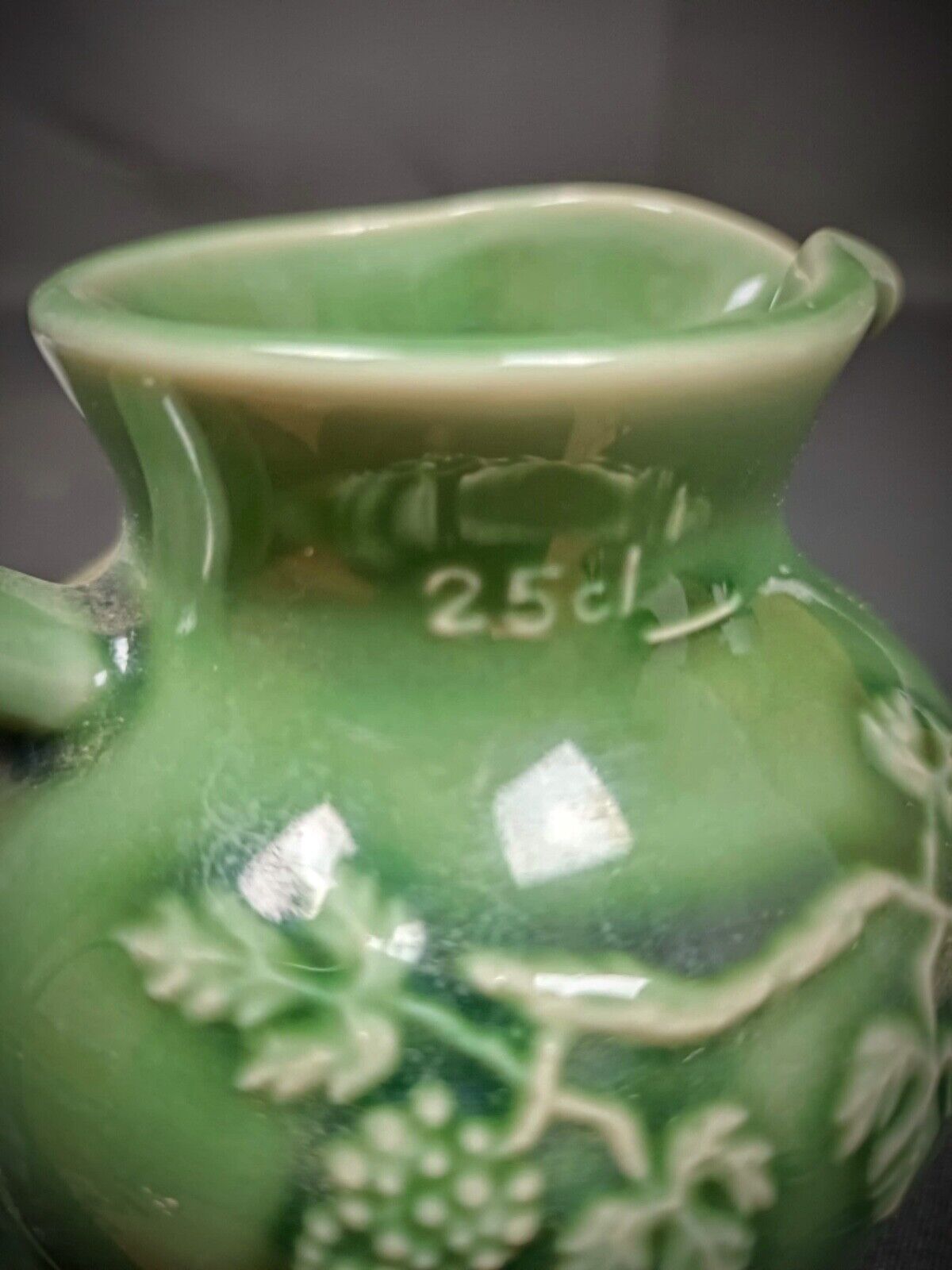Rustic ceramic pitcher with painted grape clusters