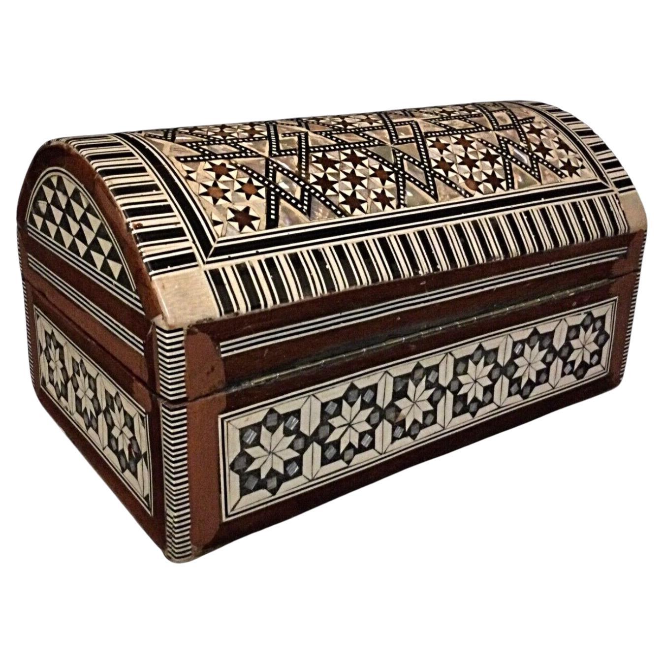 Antique Syrian jewelry box with mother-of-pearl inlay and red velvet interior.