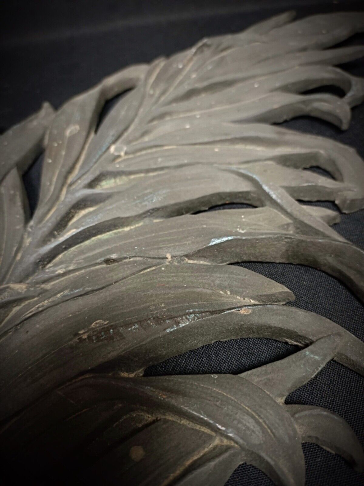 Detail of raised letter “Gadzarts” on bronze background