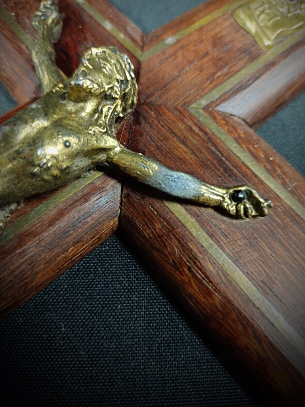 Wooden cross texture and grain visible behind corpus