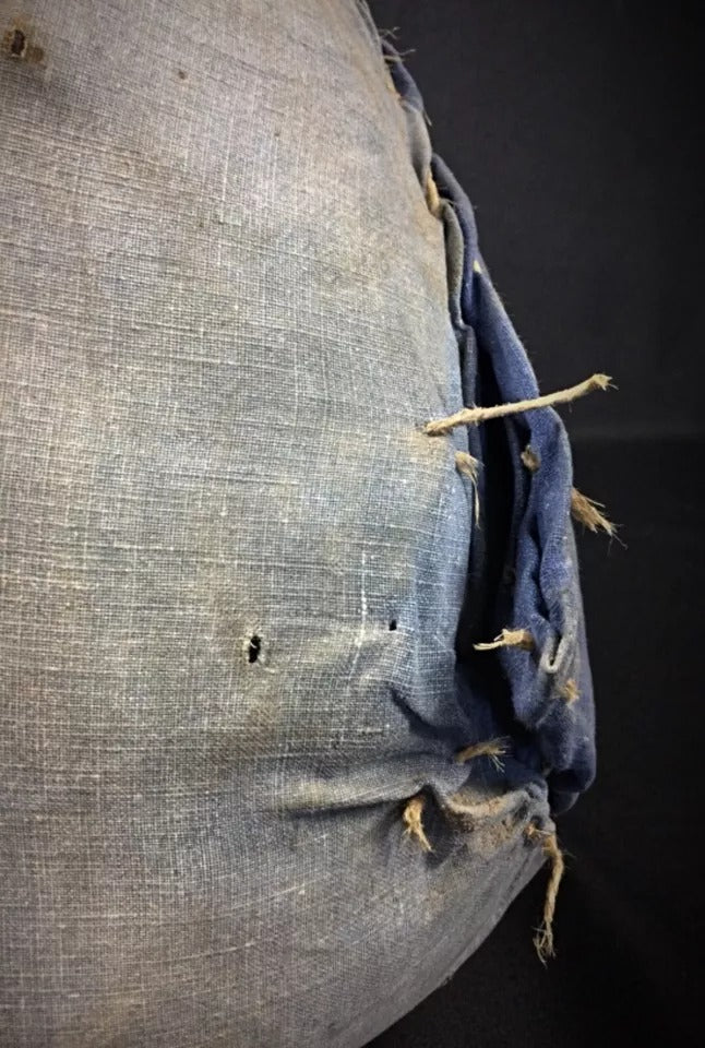 The bottle displayed on a wooden table in a rustic kitchen or dining setting.