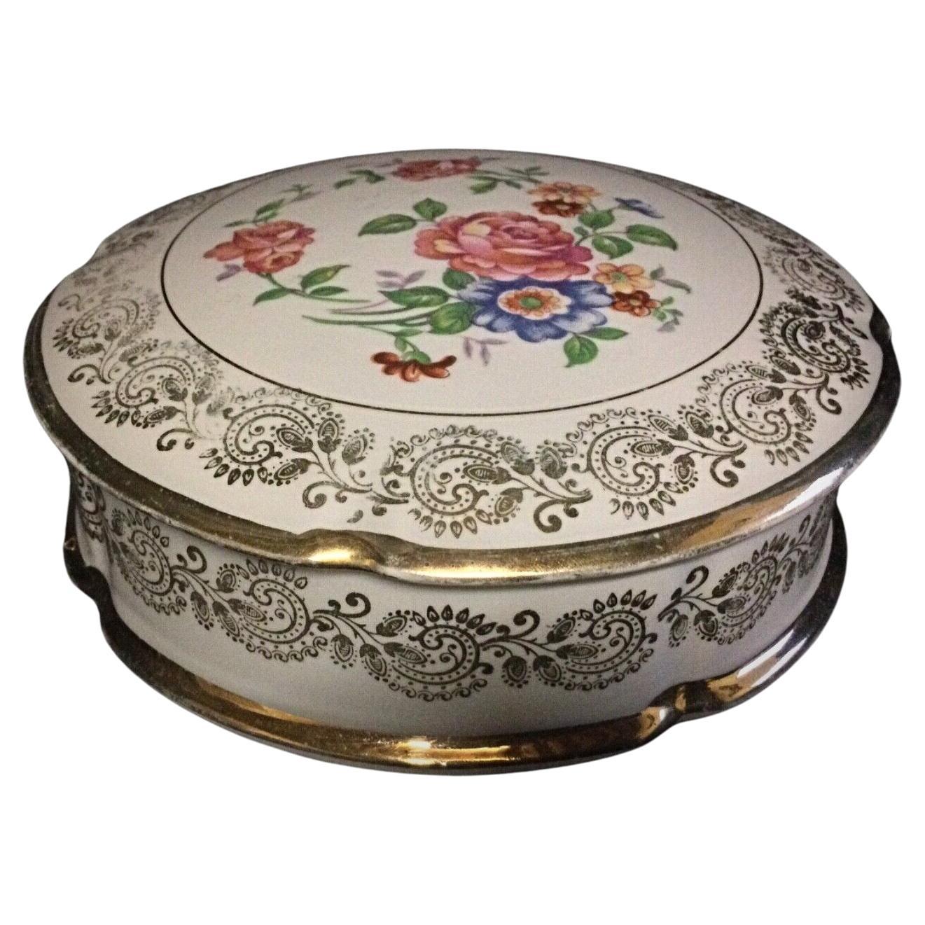 Vintage porcelain bonbonnière with floral decorations and gold trim
