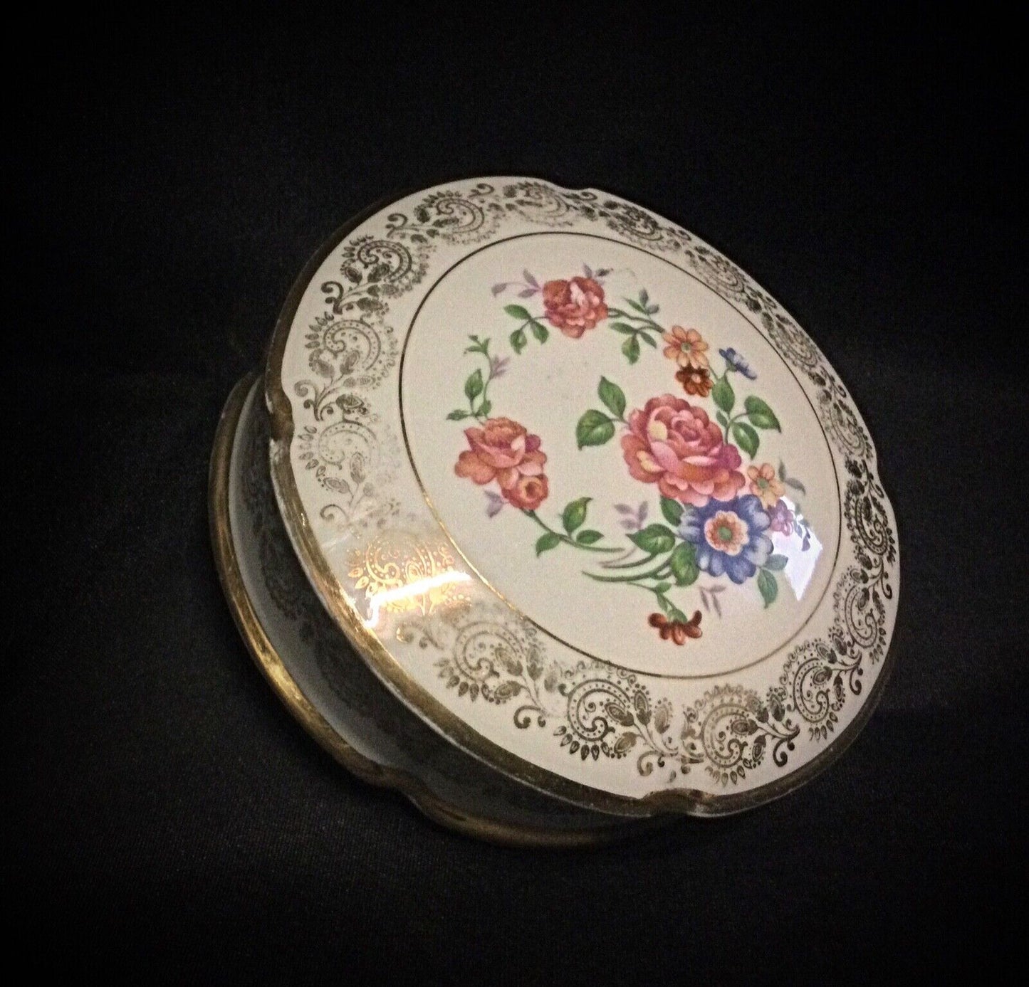 Delicate gold trim on the edge of the porcelain bonbonnière
