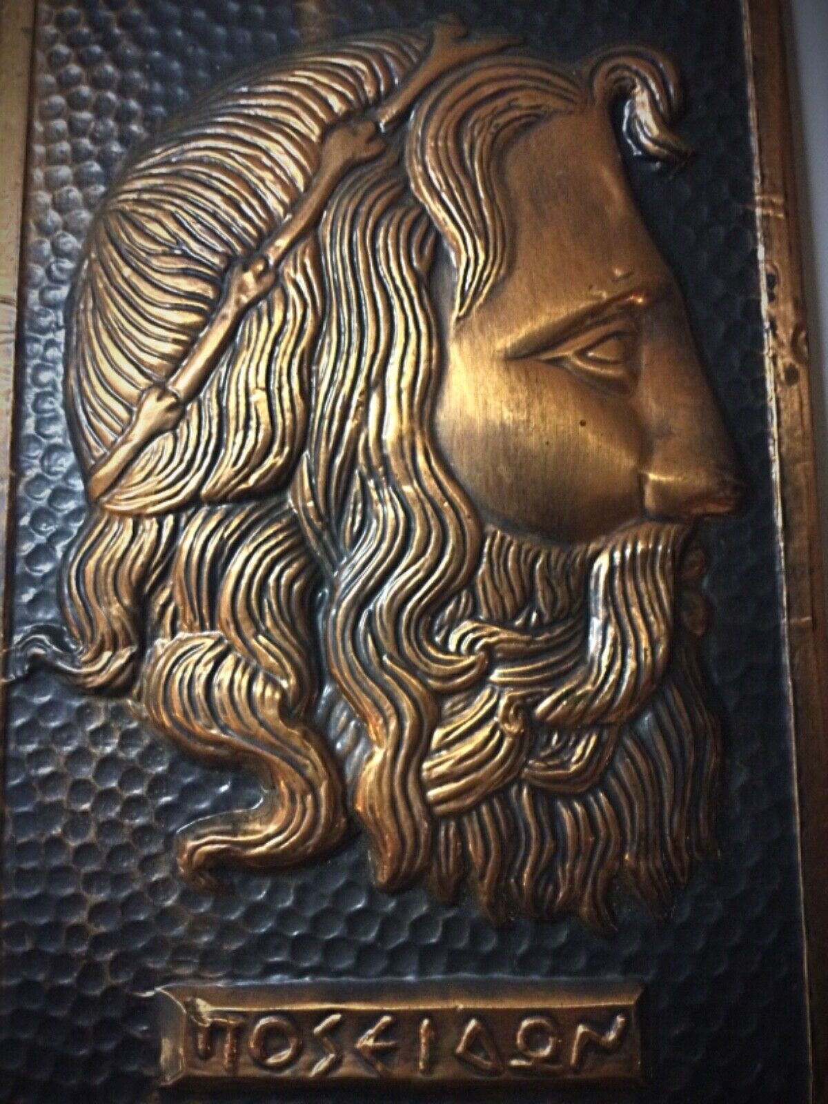 Side view of a hammered copper mythological artwork