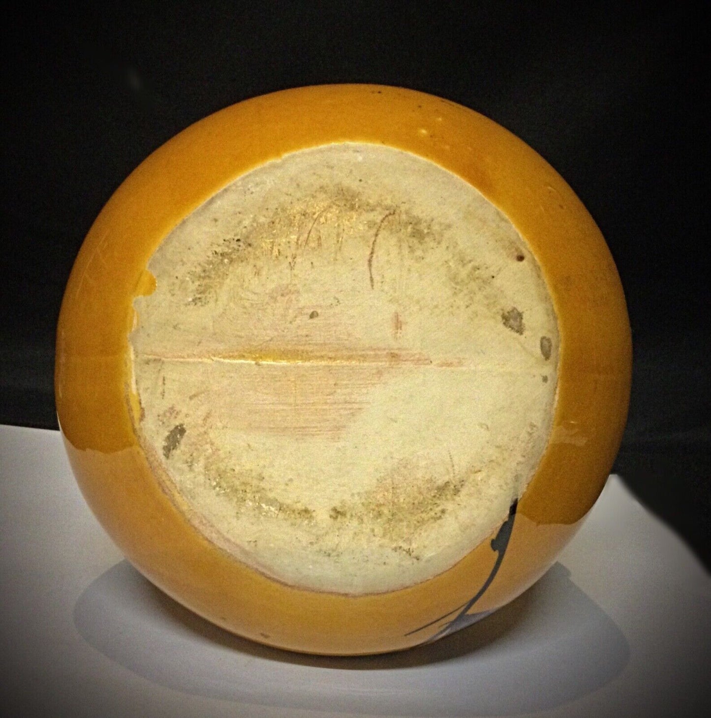 Lid of vintage faience pot showing minor dents