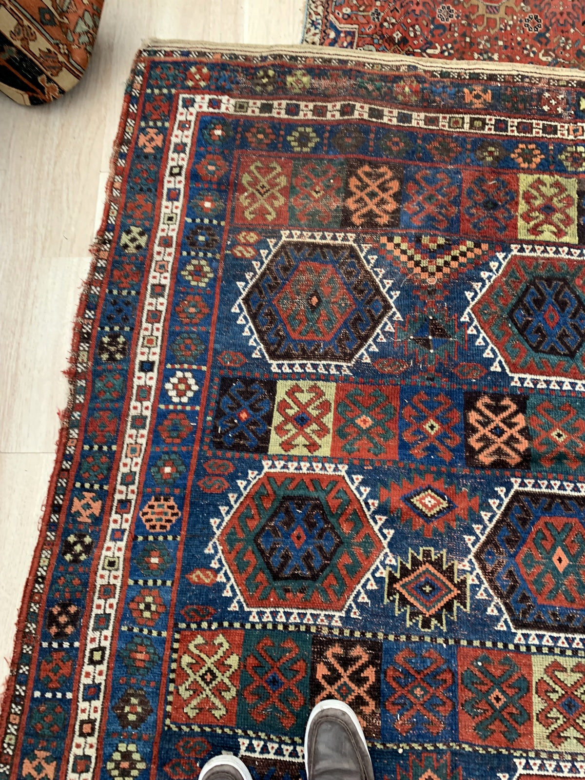 Decorative rug with geometric patterns on a floor.