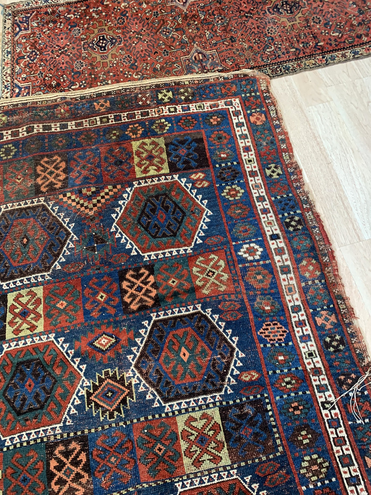 Close-up of a patterned rug with geometric designs on a wooden floor.