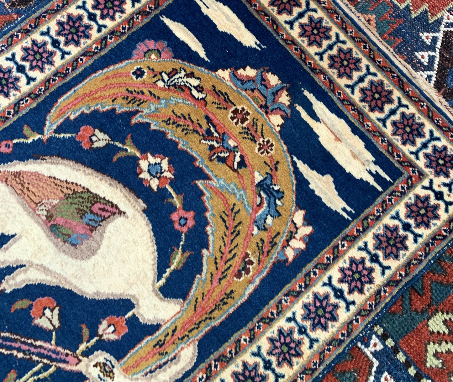 tabriz rug detail with red and green floral motifs