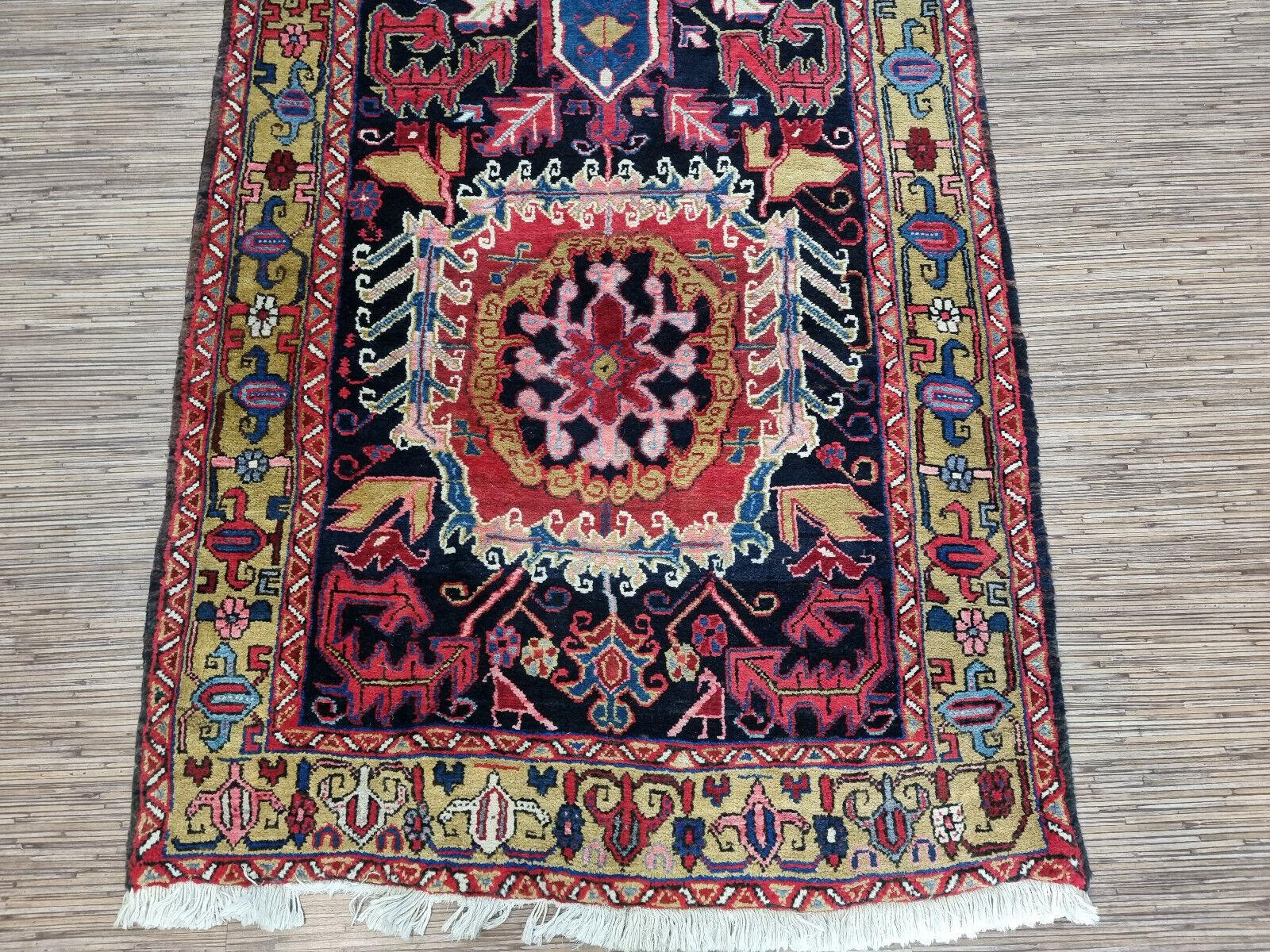 Close-up of vibrant color contrast on Handmade Antique Persian Heriz Runner Rug - Detailed view showcasing the rich color contrast between the red, blue, white, and yellow hues.