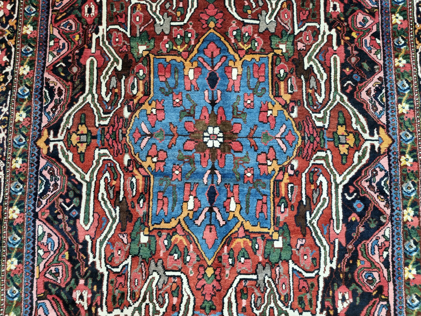 Close-up of intricate floral patterns on Handmade Antique Persian Bakhtiari Rug - Detailed view highlighting the intricate floral patterns woven into the rug.