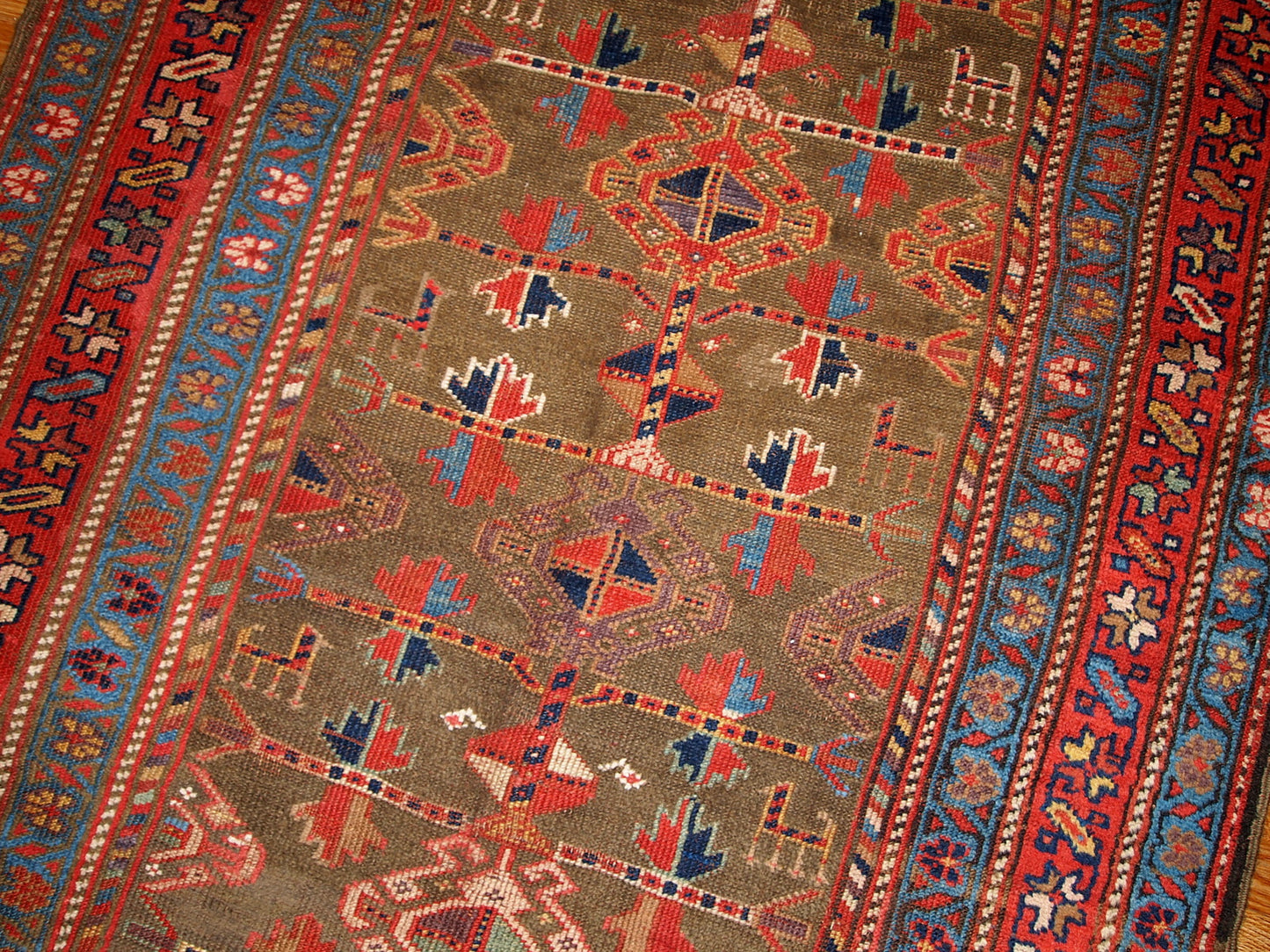 Antique Persian Kurdish rug in swampy green, red and blue colours. This rug is from the end of 19th century in good condition.