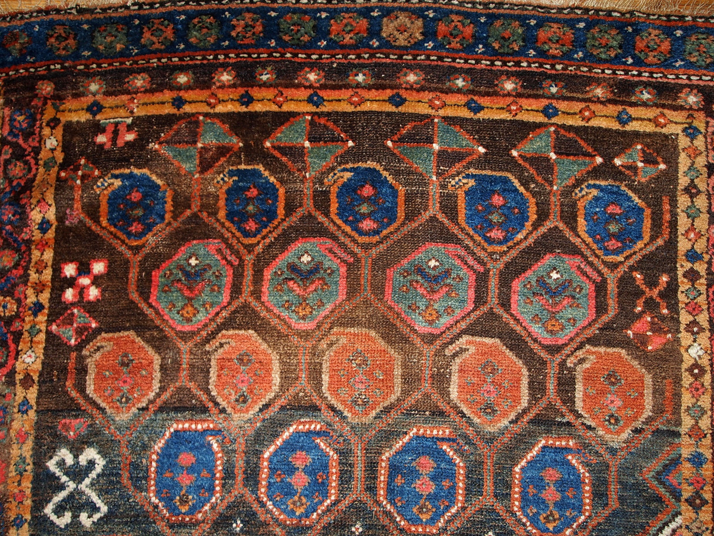 Antique Persian Kurdish rug in chocolate brown shade with repeating pattern. This rug is in original good condition.