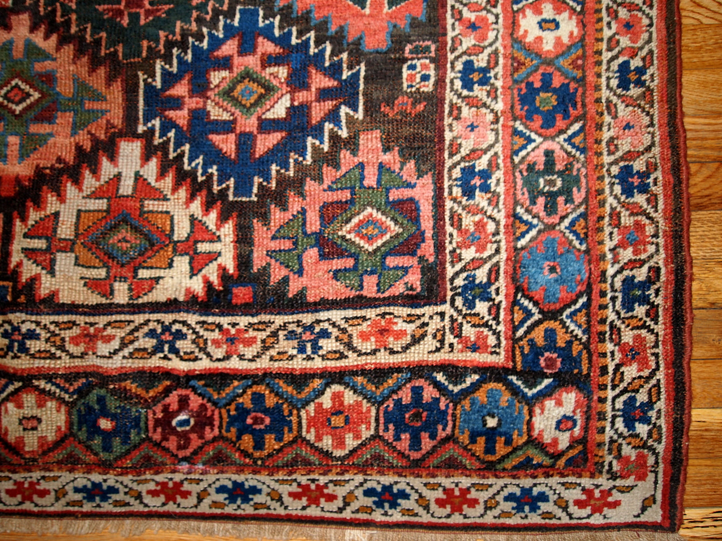 Antique Persian Kurdish rug in chocolate brown background color and repeating pattern. This rug has Jaff Kurdish design. It is in original good condition.