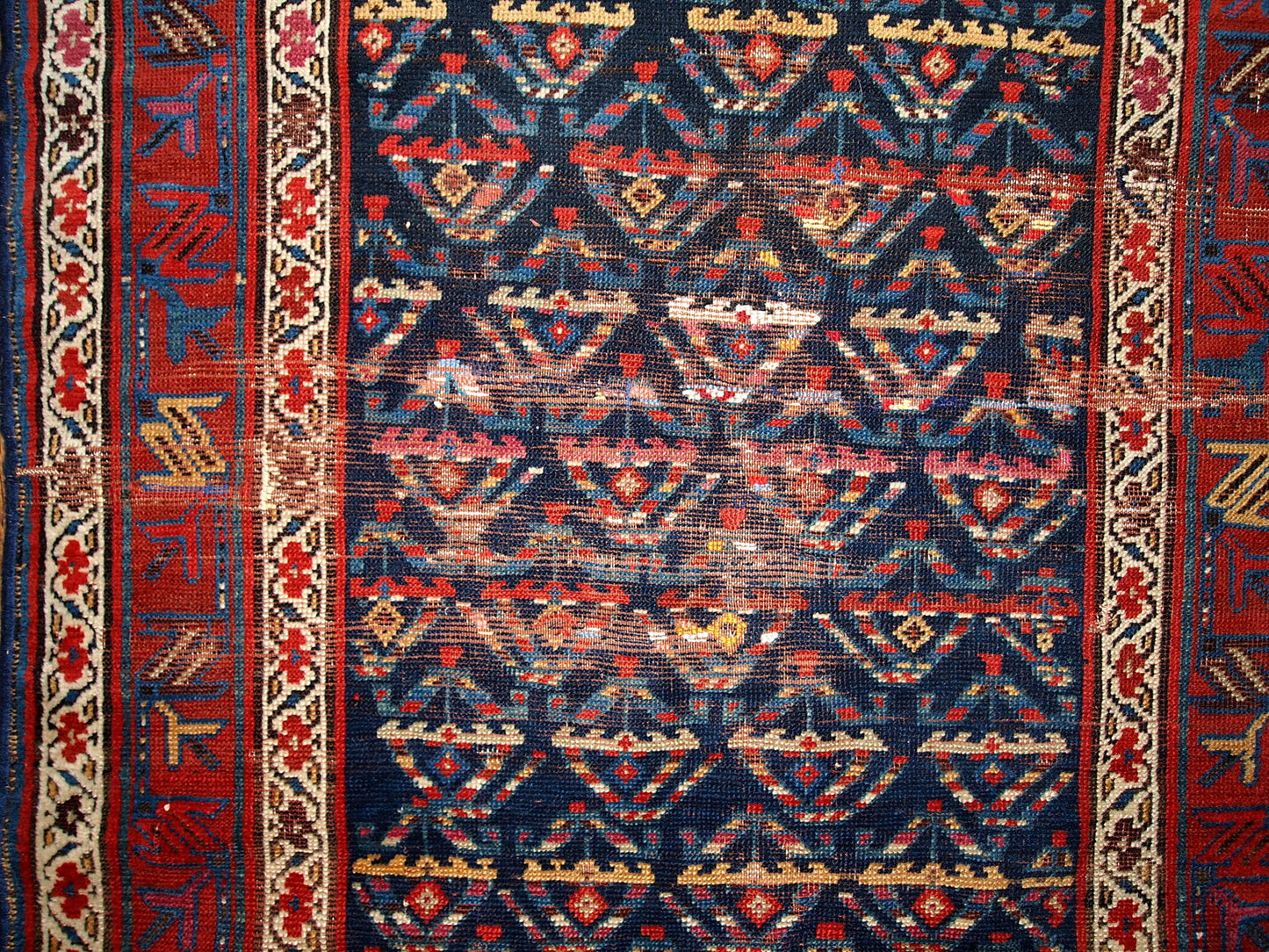 Antique hand made Persian Kurdish distressed runner in dark blue shade. The rug has some age damages and a patch.