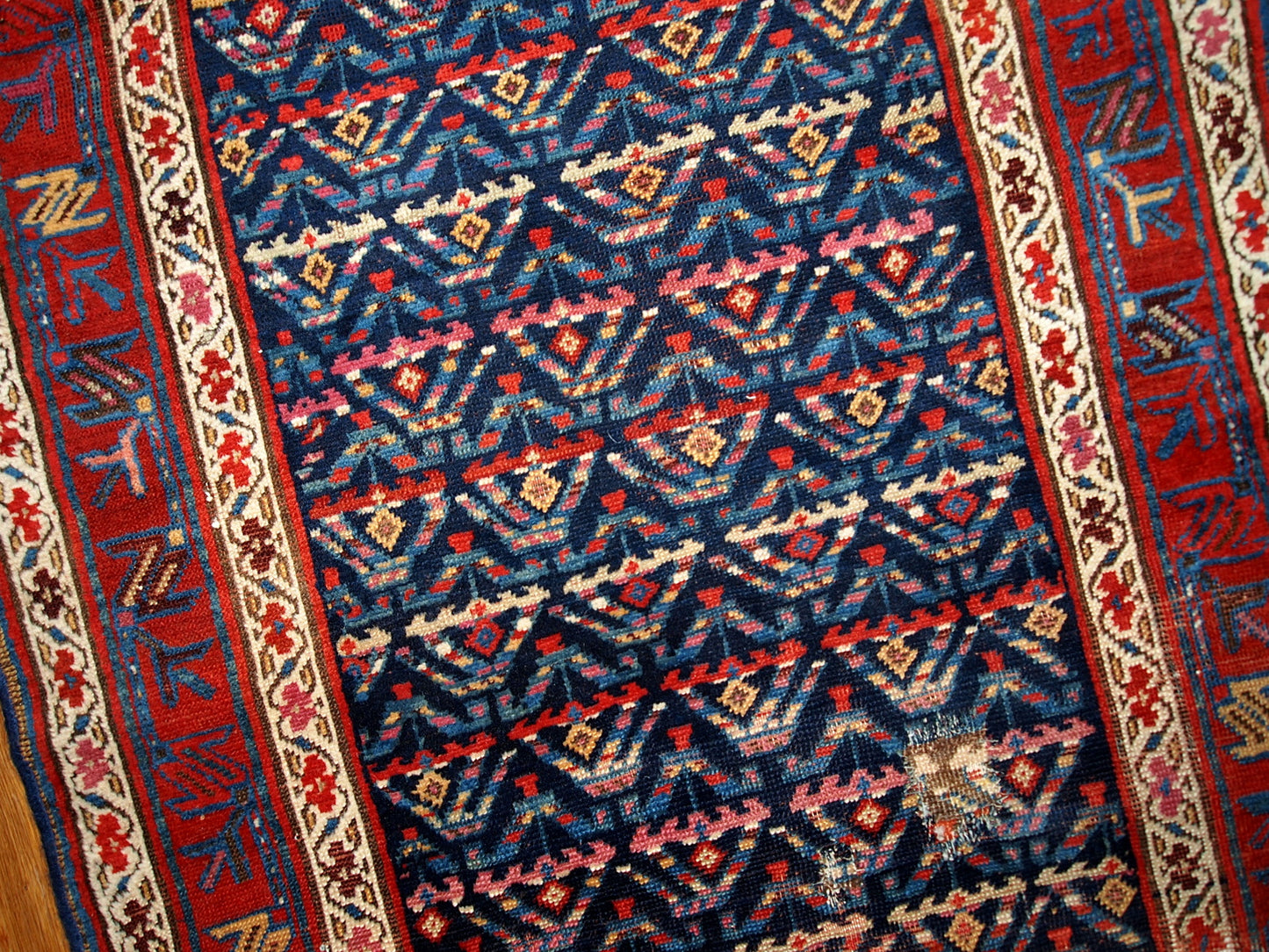 Antique hand made Persian Kurdish distressed runner in dark blue shade. The rug has some age damages and a patch.