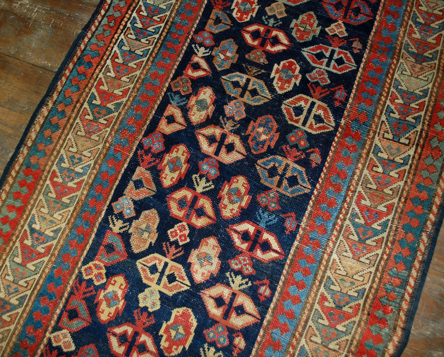 Antique handmade Caucasian Gendje rug in good condition. The rug has dark blue field covered in tribal figures, made in the end of 19th century.