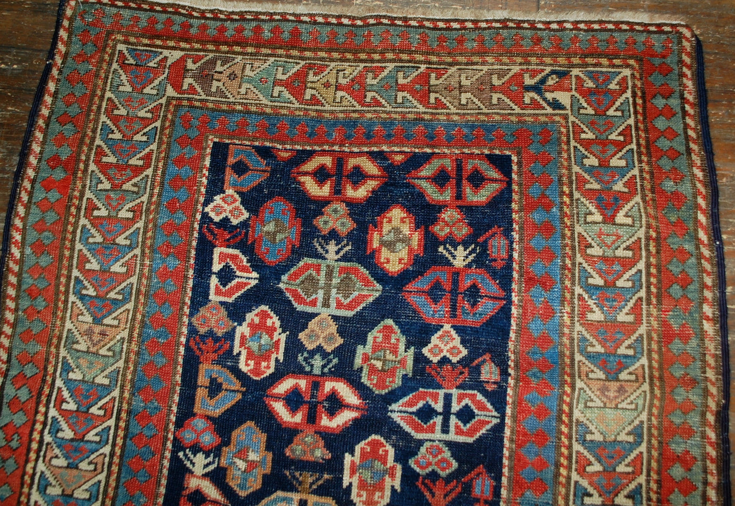 Antique handmade Caucasian Gendje rug in good condition. The rug has dark blue field covered in tribal figures, made in the end of 19th century.
