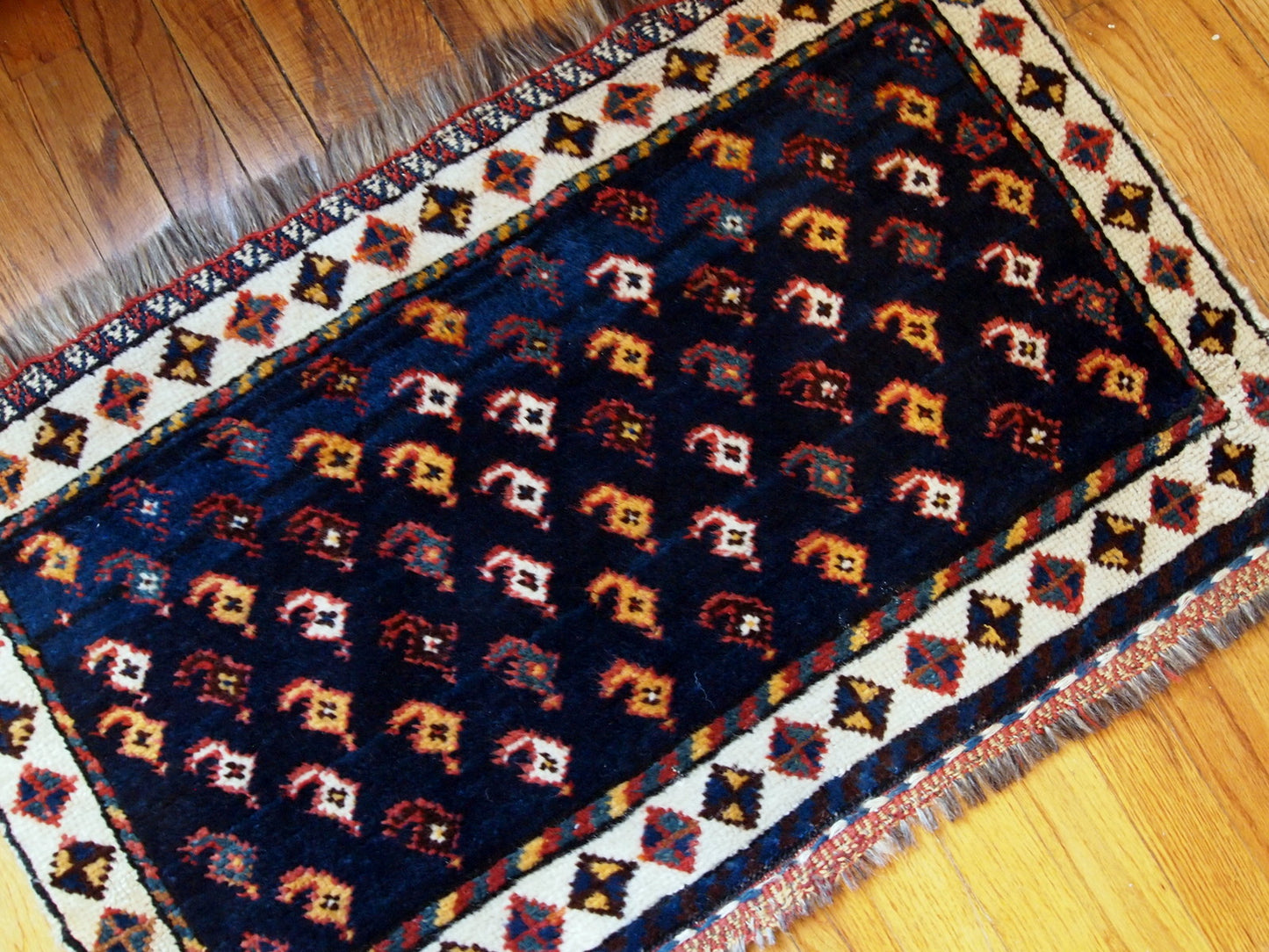 Antique collectible Persian Luri bagface in original good condition. Navy blue background with a slight abrash and colorful pattern in yellow, red and pink shades.