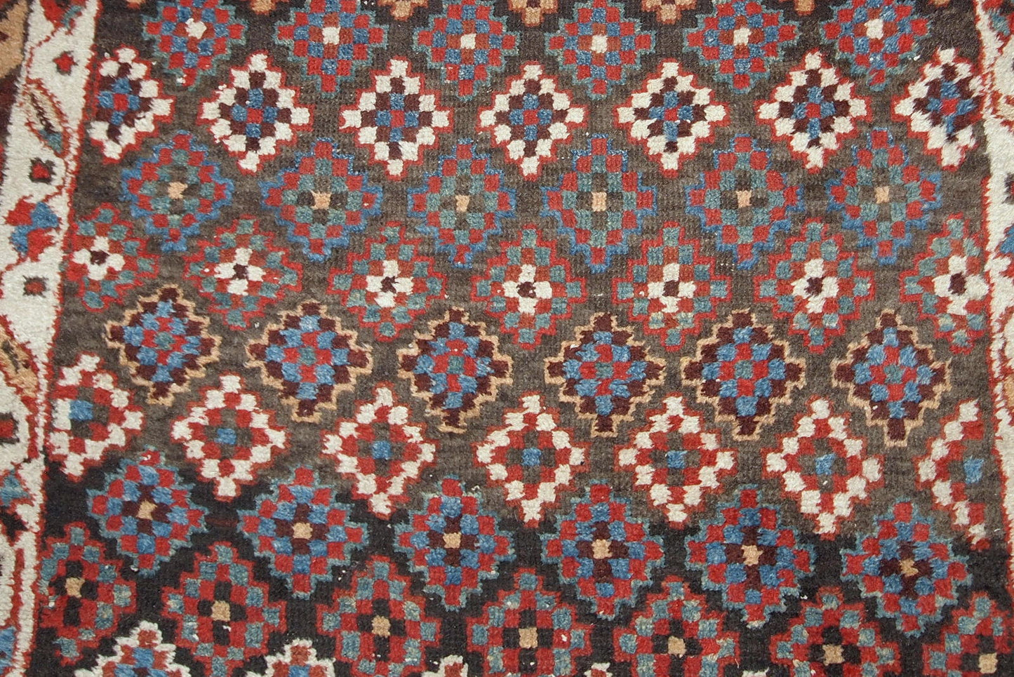 Antique handmade Northwest Persian rug in original good condition from 1880s. The rug made in repeating geometric pattern in colorful shades.