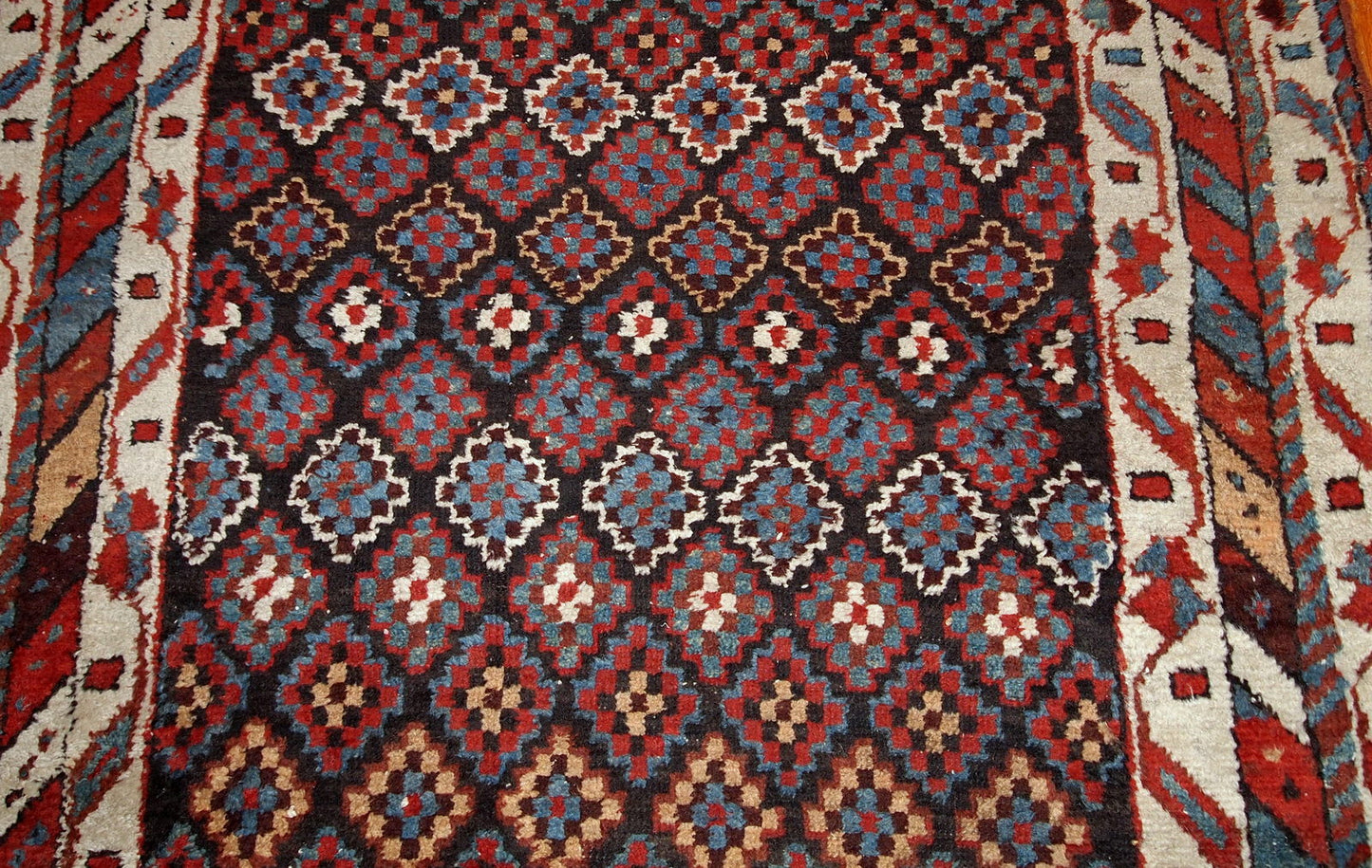 Antique handmade Northwest Persian rug in original good condition from 1880s. The rug made in repeating geometric pattern in colorful shades.