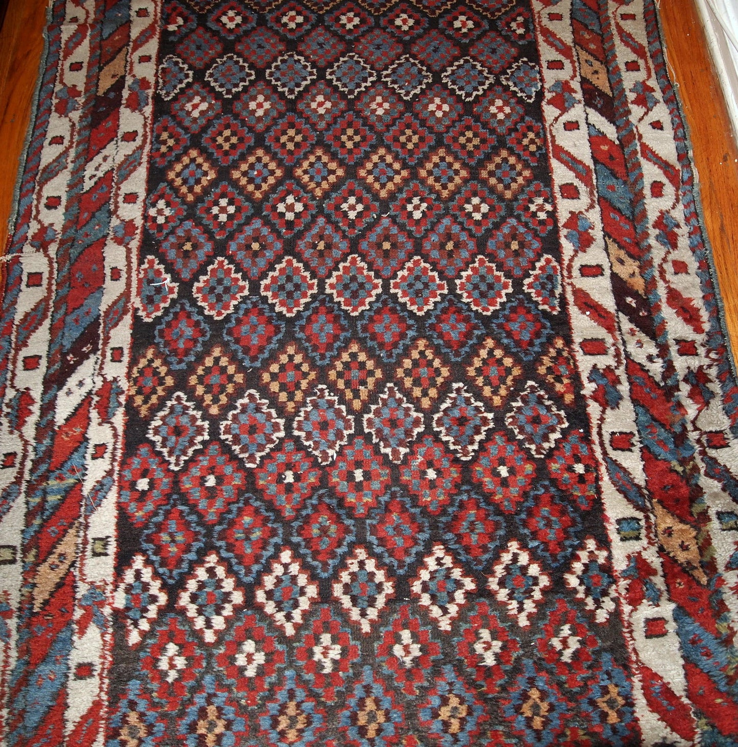 Antique handmade Northwest Persian rug in original good condition from 1880s. The rug made in repeating geometric pattern in colorful shades.