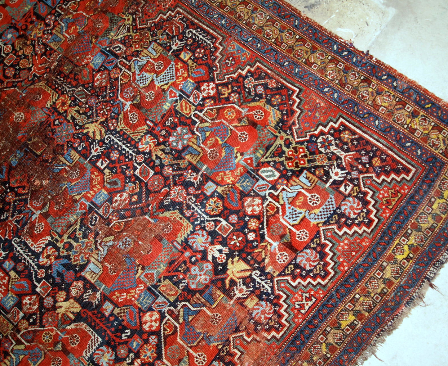 Antique handmade collectible Khamseh rug from the mid-18th century. It is in bright natural colours and in distressed condition.
