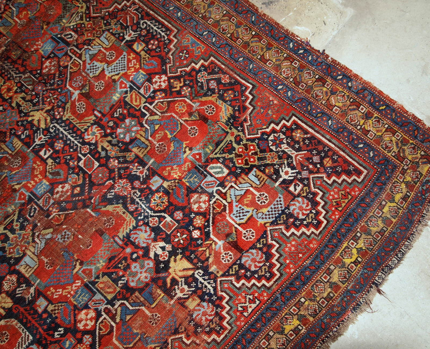 Antique handmade collectible Khamseh rug from the mid-18th century. It is in bright natural colours and in distressed condition.