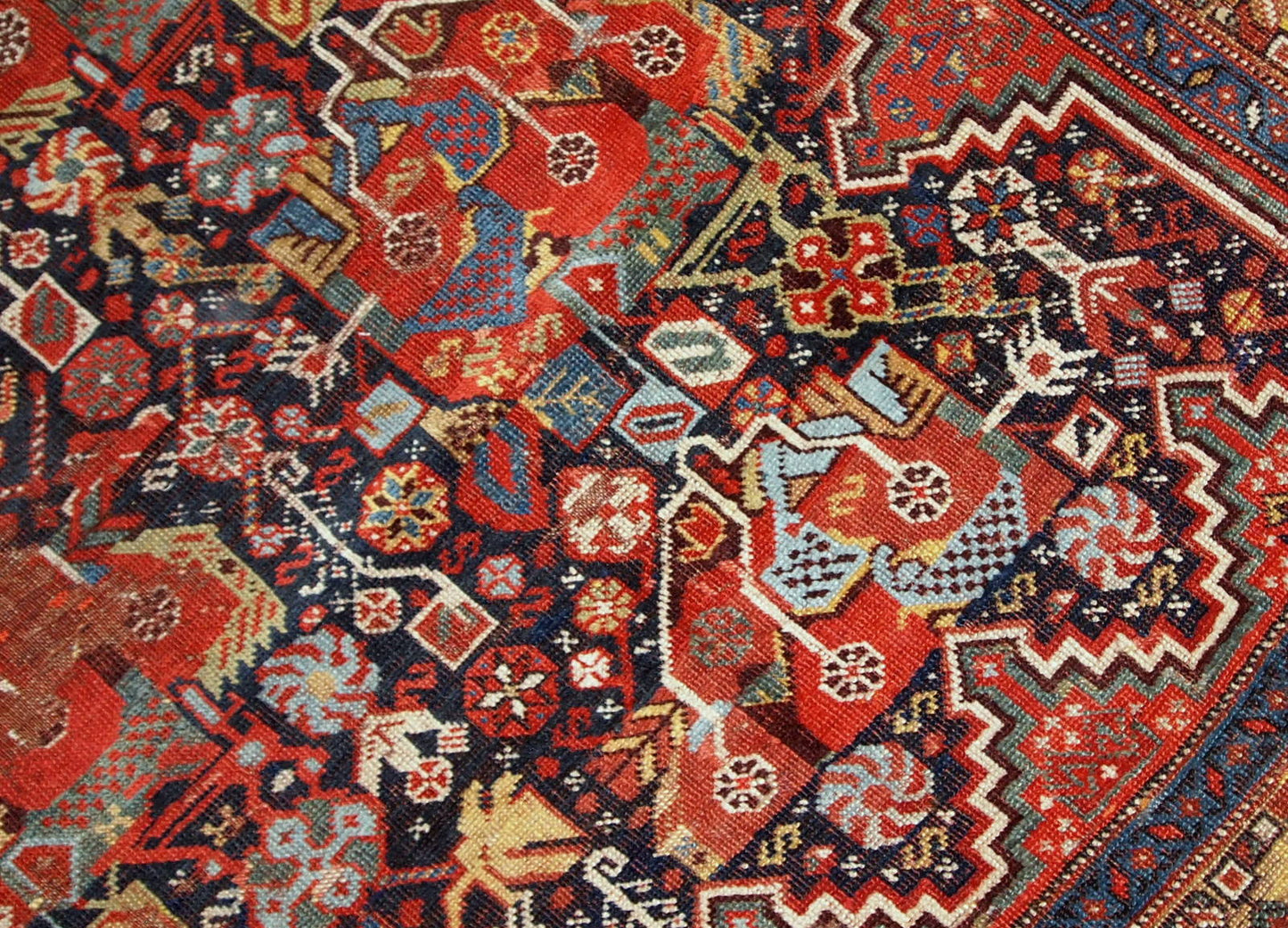 Antique handmade collectible Khamseh rug from the mid-18th century. It is in bright natural colours and in distressed condition.