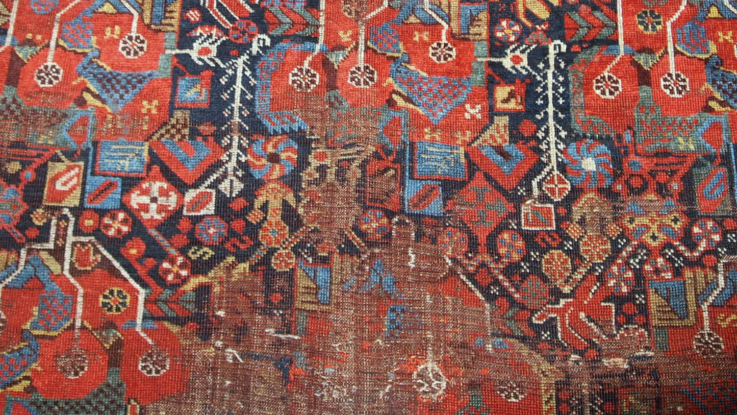 Antique handmade collectible Khamseh rug from the mid-18th century. It is in bright natural colours and in distressed condition.