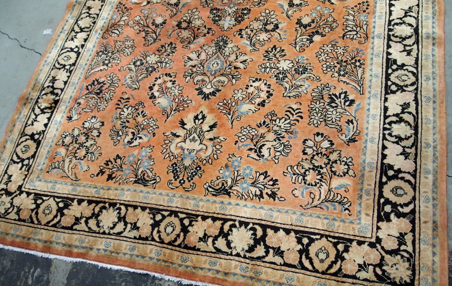 Antique hand made Persian Sarouk rug in salmon shade. The rug is from the beginning of 20th century in original good condition.