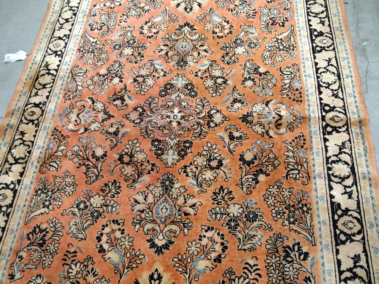 Antique hand made Persian Sarouk rug in salmon shade. The rug is from the beginning of 20th century in original good condition.
