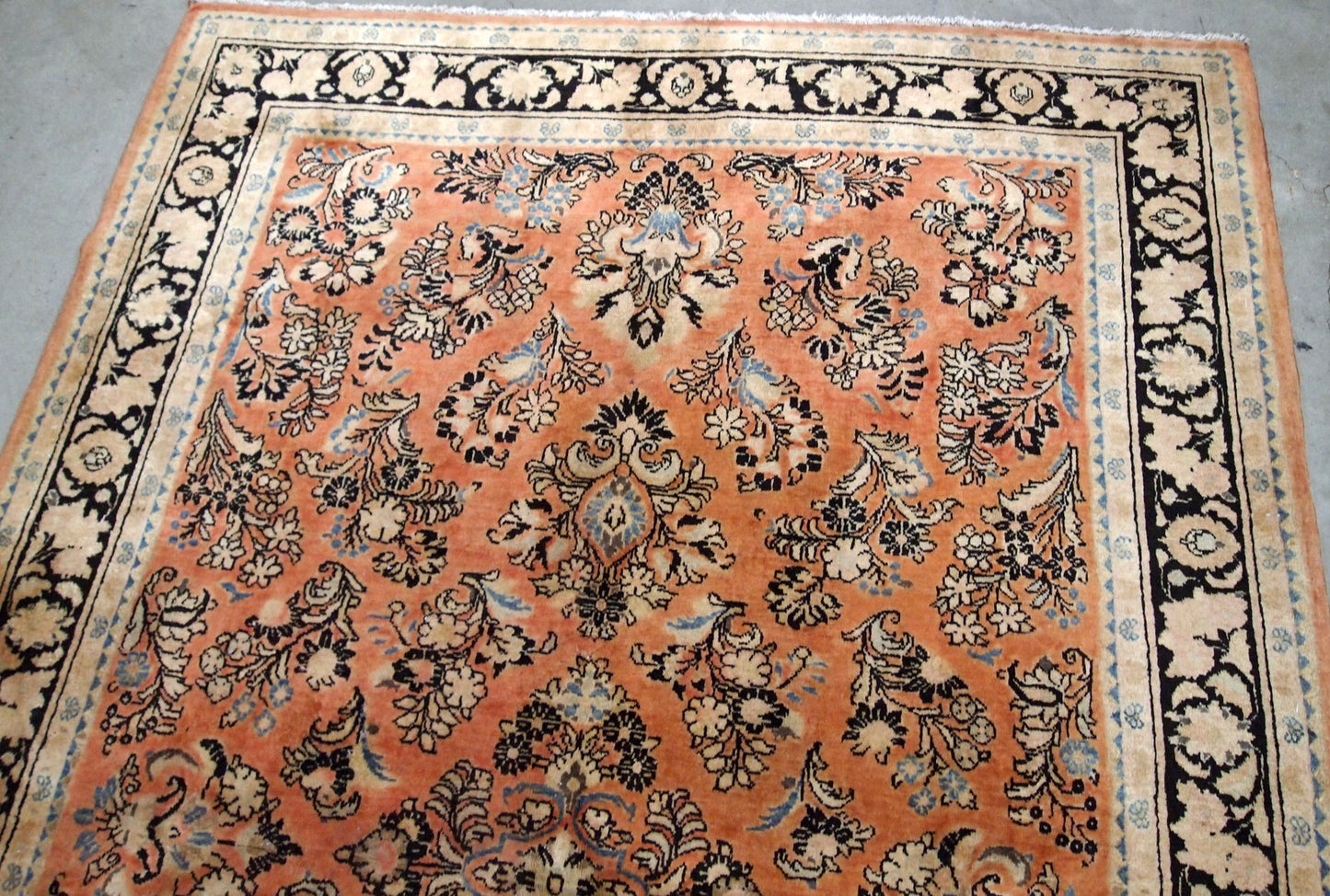 Antique hand made Persian Sarouk rug in salmon shade. The rug is from the beginning of 20th century in original good condition.