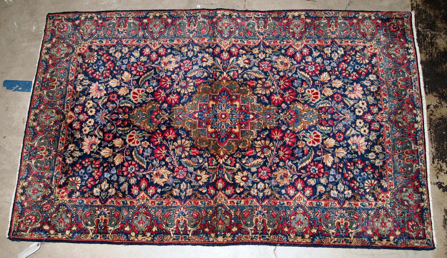 Handmade antique Kerman rug from the beginning of 20th century. The rug is in original good condition made in colorful shades and floral design.