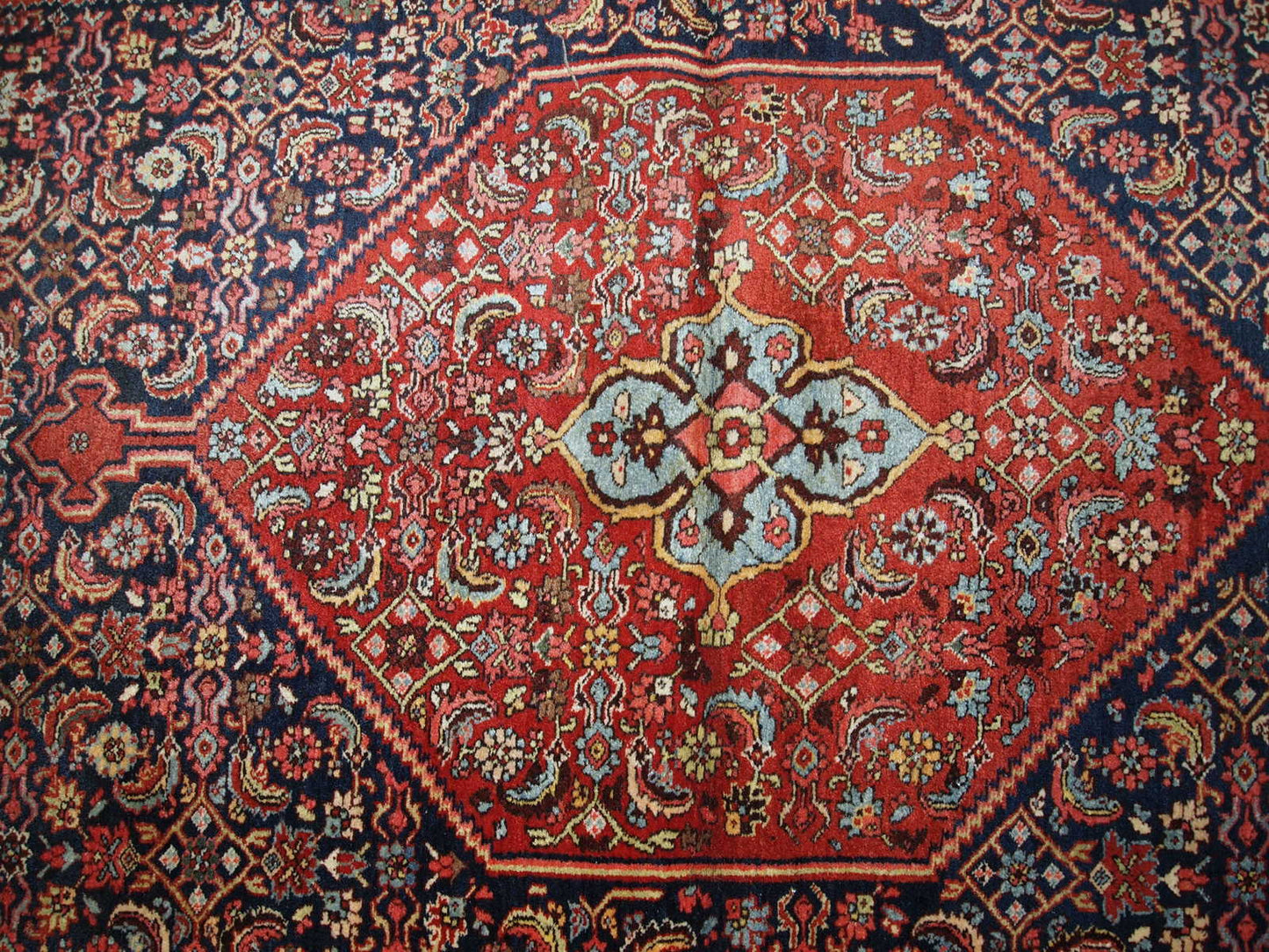 Handmade antique Bidjar rug from the beginning of 20th century. The rug is in original good condition made in red and blue wool.