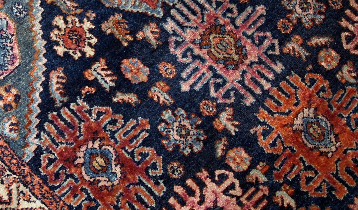 Handmade antique Malayer rug from the beginning of 20th century. The rug is in original good condition, has all-over design on navy blue background.