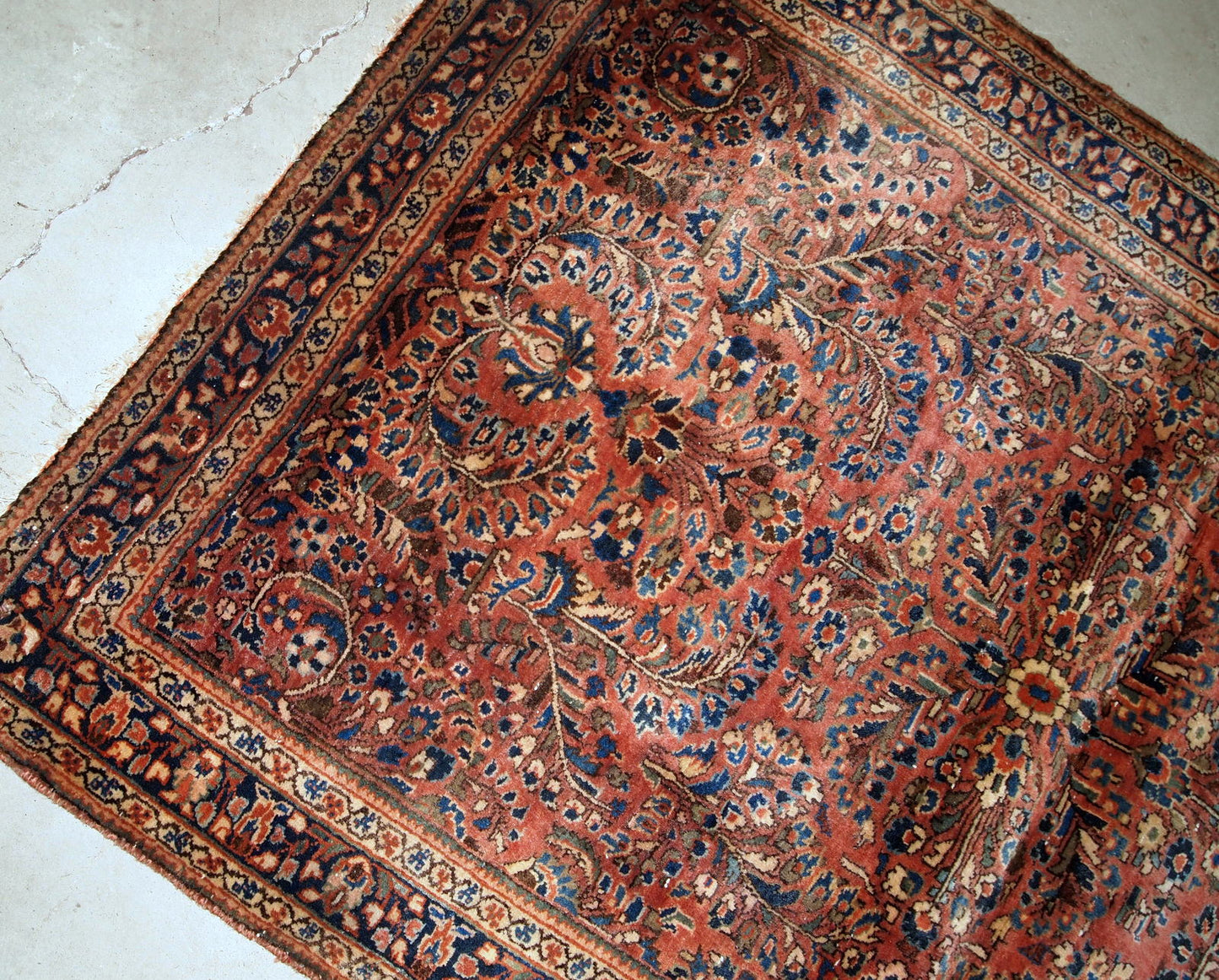 Hand-weaved antique Sarouk rug from the beginning of 20th century. The rug is in original good condition, made in classic floral design.