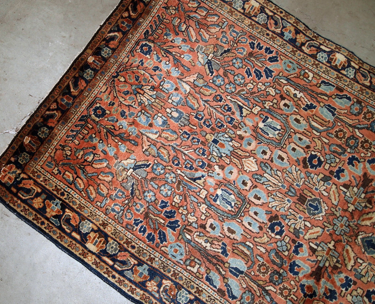 Hand-weaved antique Sarouk rug from the beginning of 20th century. The rug is in original good condition, made in classic floral design in red and sky blue shades.