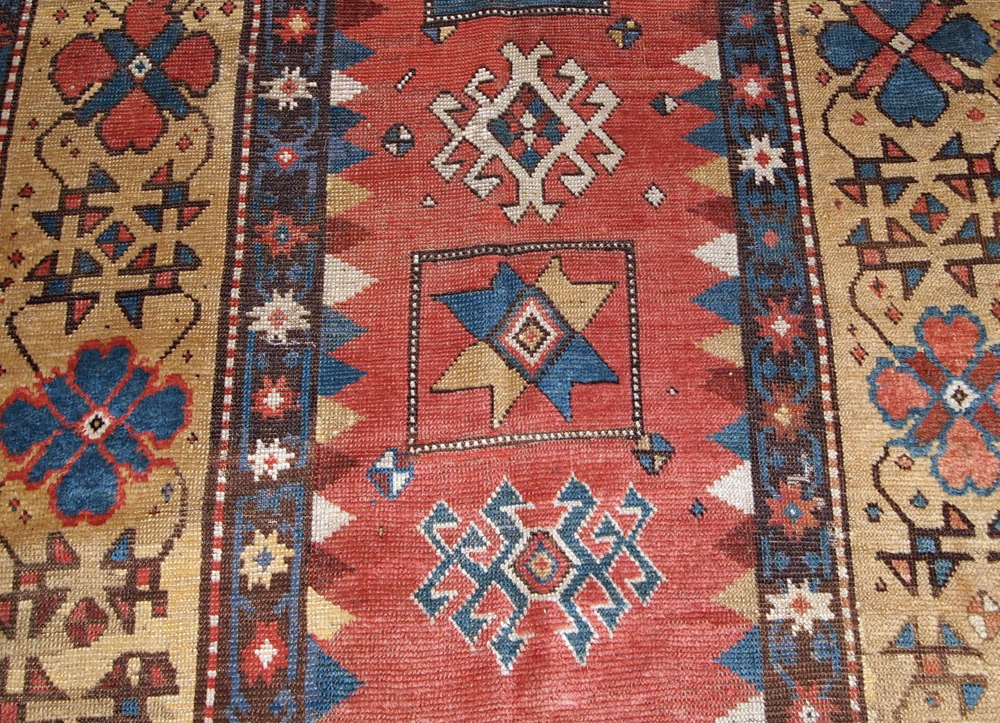 Handmade antique Caucasian Kazak rug in red and yellow shades. The rug is from the end of 19th century from Russia in original good condition.