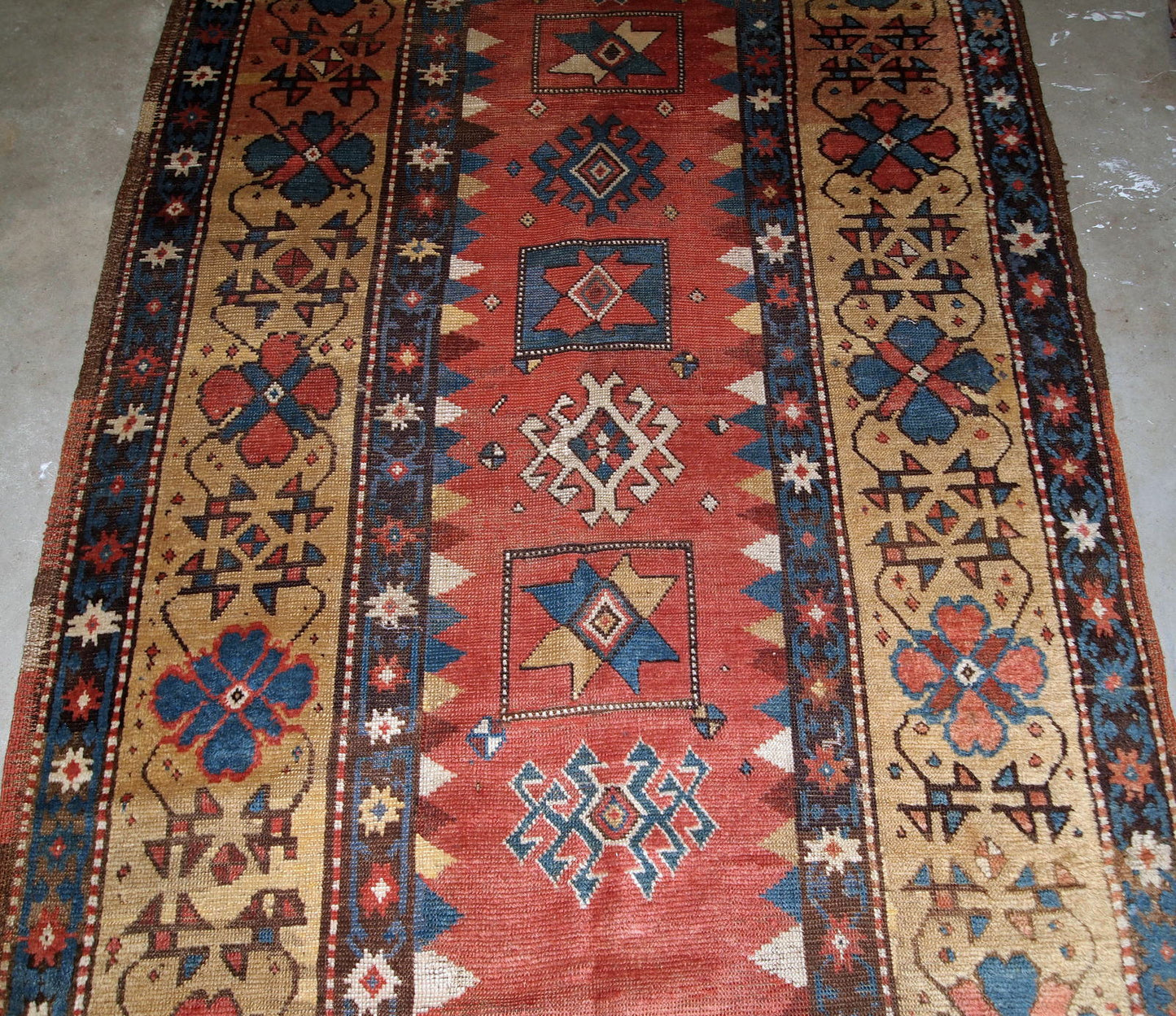 Handmade antique Caucasian Kazak rug in red and yellow shades. The rug is from the end of 19th century from Russia in original good condition.